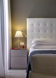 1 dormitorio con cama y mesita de noche con lámpara en Hotel Orient & Pacific, en Lido di Jesolo