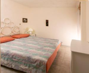 1 dormitorio con 1 cama grande con almohadas de color naranja en Bungalow cerca de la playa de La Mata, en Torrevieja