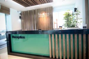 a reception desk in a room with a sign at Smith Residence in Suratthani