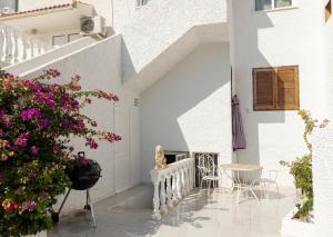 Casa blanca con escaleras blancas y flores rosas en Bungalow cerca de la playa de La Mata, en Torrevieja
