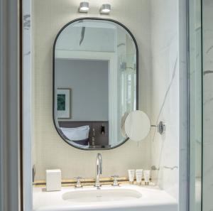 a bathroom with a sink and a mirror at Hôtel La Tamise - Esprit de France in Paris