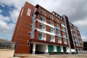 a tall building with green and white windows at Smith Residence in Suratthani