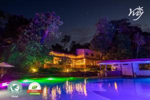 a building with a swimming pool at night at Yvy Hotel de Selva in Puerto Iguazú