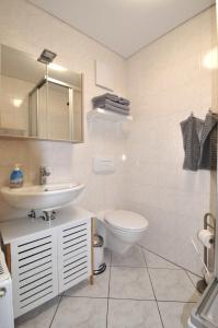 une salle de bains avec lavabo, toilettes et miroir dans l'établissement Zum Augustiner I, Erfurt Zentrum, à Erfurt 27 autres photos