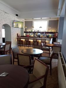 restauracja ze stołami i krzesłami oraz bar w obiekcie Chase Hotel w mieście Whitehaven