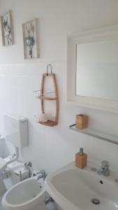 a white bathroom with a toilet and a sink at Attico mansardato davanti Casinò in Sanremo