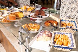 um buffet com muitos tipos diferentes de pão e pastelaria em Victoria Plaza Hotel em Palmas