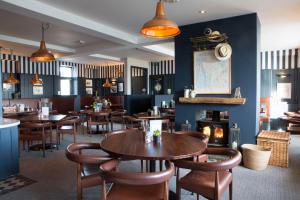 a restaurant with tables and chairs and a fireplace at Seacroft in Holyhead