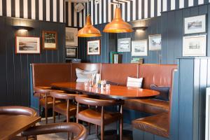 a dining room with a wooden table and leather chairs at Seacroft in Holyhead