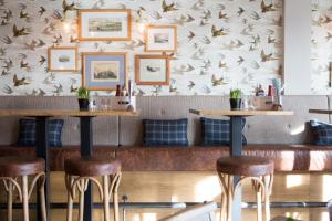 a restaurant with bar stools and a wall with birds at Seacroft in Holyhead