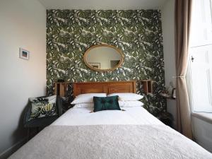 um quarto com uma cama grande e um espelho em Cowrie Guest House em Berwick-Upon-Tweed