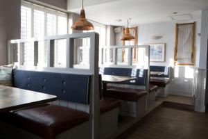 a dining room with chairs and tables and windows at Seacroft in Holyhead