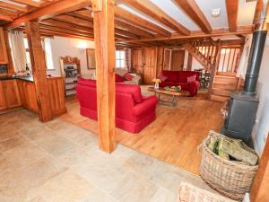 uma sala de estar com sofás vermelhos e um fogão em Cowslip Cottage em Haverfordwest