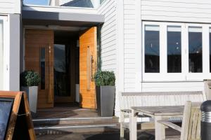 a porch of a house with a wooden door and a table at Seacroft in Holyhead