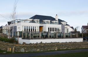 a large white house with a stone wall at Seacroft in Holyhead