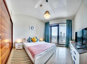 - une chambre avec un grand lit et une grande fenêtre dans l'établissement 5 Sparkle Tower Apt by Swarovski, Dubai Marina, à Dubaï