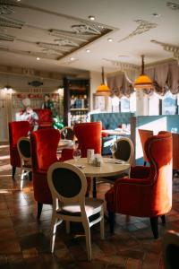 un restaurante con mesas, sillas rojas y una barra en Boutique Hotel Modern, en Yaroslavl