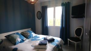 a bedroom with a bed with blue walls and a window at La Zénitude chambre d hôte in Chamarandes