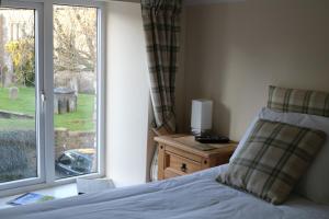 a bedroom with a bed and a large window at Dent Stores B&B in Dent