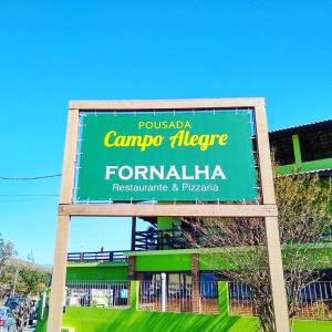 un grand panneau vert devant un bâtiment dans l'établissement Pousada Campo Alegre, à Itatiaia