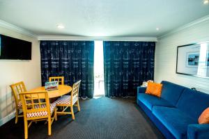 a living room with a blue couch and a table at Port Royal Oceanfront Hotel in Wildwood Crest