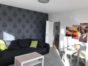 ein Wohnzimmer mit einem schwarzen Sofa und einem Tisch in der Unterkunft Haus Kyllblick in Birresborn