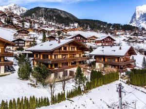 una ciudad con edificios cubiertos de nieve y una montaña en Apartment Eiger - GRIWA RENT AG, en Grindelwald 9 fotos más