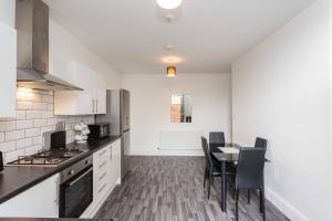 a kitchen and dining room with a table and chairs at Cherry Property - Plum Suite in Blackpool