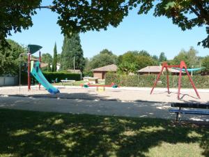 un parc avec une aire de jeux avec un toboggan dans l'établissement Gites de la Garenne, à Nérac