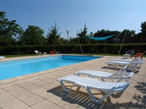 - une piscine avec 2 chaises longues à côté dans l'établissement Gites de la Garenne, à Nérac