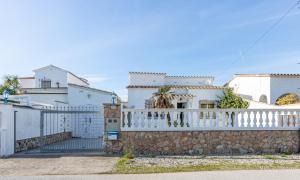 エンプリアブラバにあるApart-rent Villa Creus 0038の門と柵のある白い家