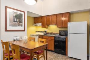 uma cozinha com uma mesa e um frigorífico branco em Residences at Daniel Webster em Merrimack