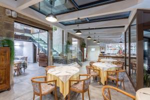 a restaurant with tables and chairs in a room at Hotel Roma in Porretta Terme