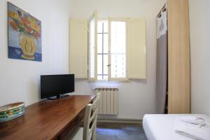 ein Schlafzimmer mit einem Schreibtisch und einem TV darauf in der Unterkunft Space, comfort and beauty near Ponte Vecchio in Florenz