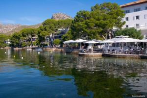 una gran masa de agua con mesas y sombrillas en Luxury Villa Phoenix, en Puerto Pollensa
