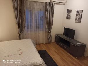 a bedroom with a bed and a flat screen tv at Apartments Roncevic in Zadar
