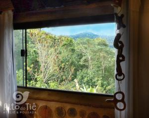a window with a view of a forest at Pousada Alto do Tiê in Paraty