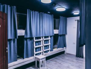 a room with two bunk beds with blue curtains at Smart Hostel in Odesa