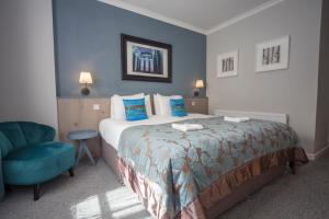 a bedroom with a bed, desk, chair, and lamp at Highfield Hotel in Houghton le Spring