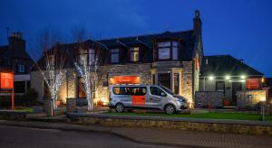 a van parked in front of a house at night at The Dunavon in Dyce