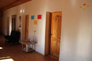 una stanza con una porta, un tavolo e una sedia di Teo Guesthouse and Camping in Mestia a Mestia