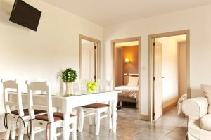 a white dining room with a white table and chairs at B&B De Fruithoeve in Hoeselt