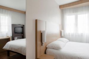 ein Hotelzimmer mit 2 Betten und einem TV in der Unterkunft ibis Lille Centre Grand Place in Lille