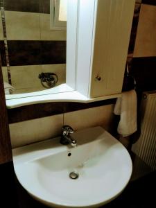 a white sink in a bathroom with a cabinet at Argiro's Apartment in Iraklitsa +19 photos