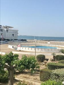 vista su una spiaggia con piscina e su un edificio di AS17378 - P4 Dans une résidence sur la plage avec vue mer et piscine a Le Grau-du-Roi