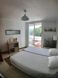 una camera da letto con un grande letto bianco e una finestra di AS17378 - P4 Dans une résidence sur la plage avec vue mer et piscine a Le Grau-du-Roi