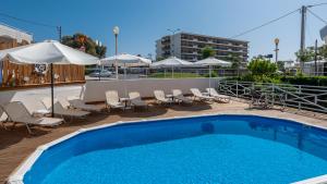 a swimming pool with chairs and tables and umbrellas at Marine Congo Hotel in Rhodes Town