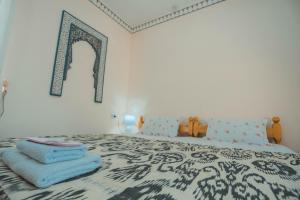 Un dormitorio con una cama con toallas azules. en Yasmin en Bukhara