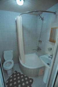 a bathroom with a toilet and a tub and a sink at Yasmin in Bukhara