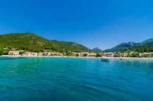 a large body of water with a beach and houses at Apartments Dalmatin in Žuljana